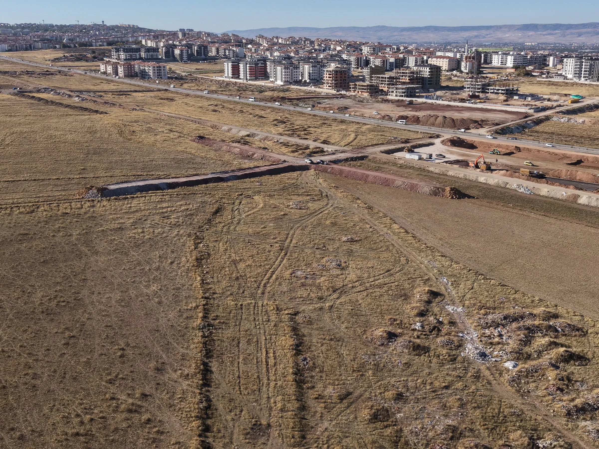 Havadan arazideki yol kavşağı ve arkada şehir