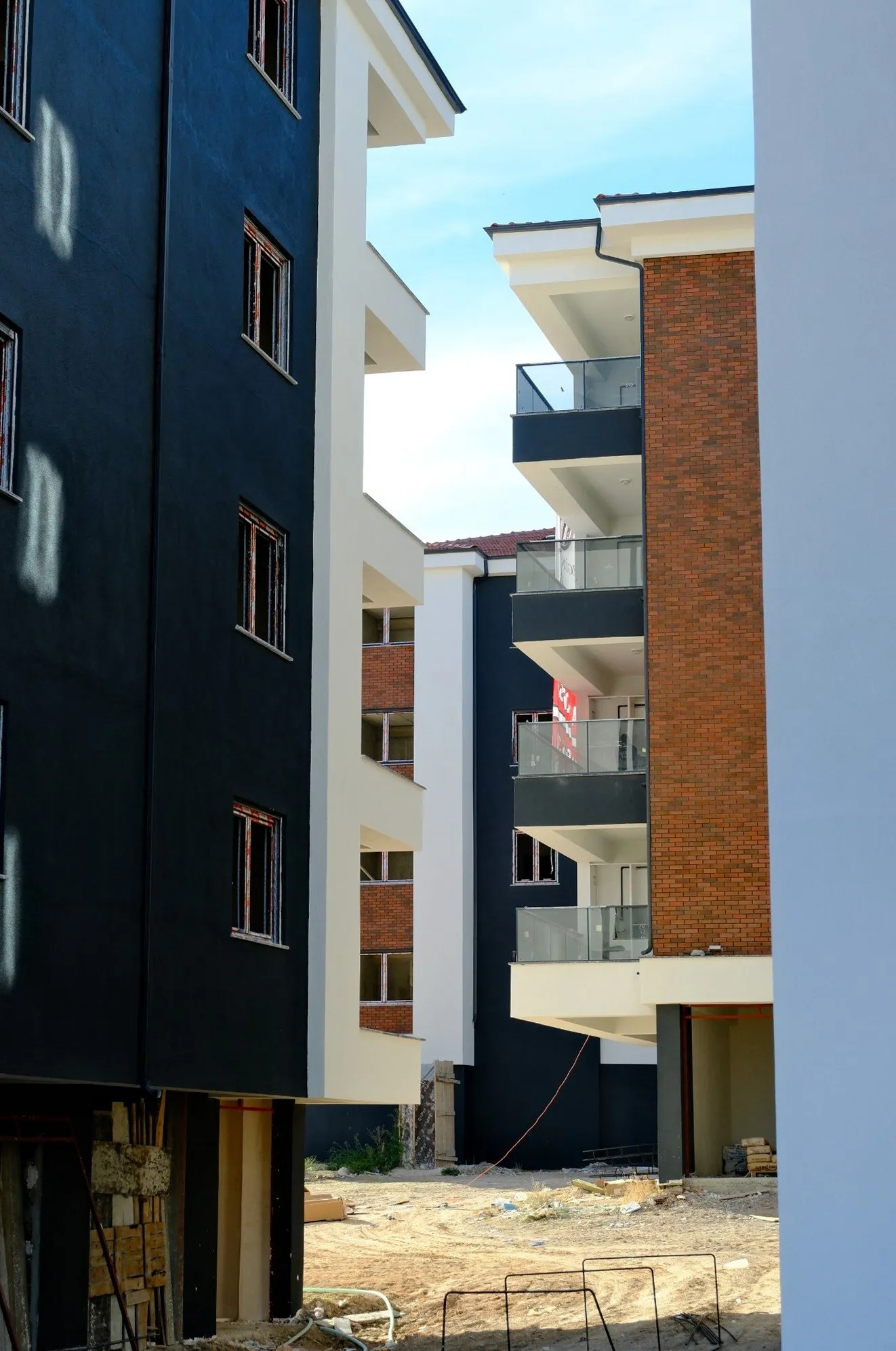 Antrasit ve tuğla cepheli bloklar arasındaki geçit